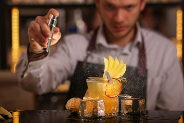 Fresh alcohol Penicillin cocktail with orange slice and ice cubes. Barmen making alcohol cocktail	