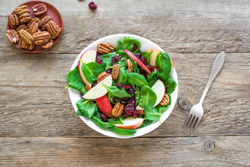 Spinach, apple salad with pecan nuts and cranberries