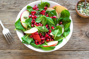 Spinach, apple salad with pomegranate seeds