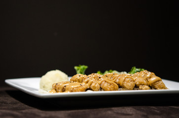 Japanese pan fry with salad and rice in black background.