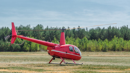 HELICOPTER - A small red machine takes off from the airport