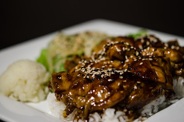 Teriyaki chicken in white plate and dark back ground.