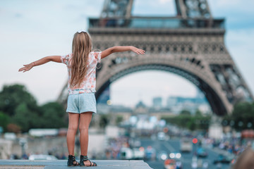 Adorable toddler girl in Paris background the Eiffel tower during summer vacation