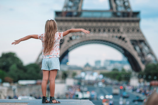 Adorable toddler girl in Paris background the Eiffel tower during summer vacation