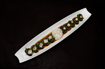 Sushi rolls in white plate and dark background © leonardogonzalez