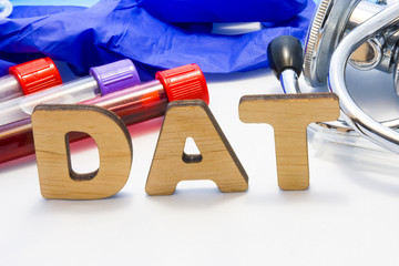 DAT abbreviature mean direct antiglobulin test with lab tubes with blood and stethoscope. Using...