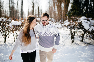 Fototapeta premium Young Beautiful Couple Taking Fun and Smiling Outdoors in Snowy Winter