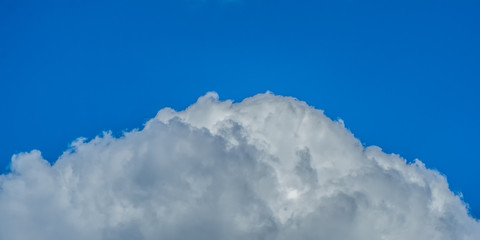 Grosse Wolke an einem blauen Himmel im Sommer als Teilausschnitt