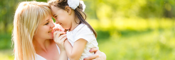 Cute young daughter on a piggy back ride with her mother.