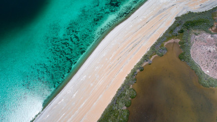 Sand, rock, and sea patterns on cristal clear waters.
