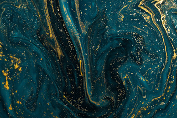 Abstract paint texture art. Natural luxury. Blue paint with gold glitter powder. Marble background.