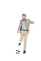 Naklejka premium smiling senior man playing football isolated on white