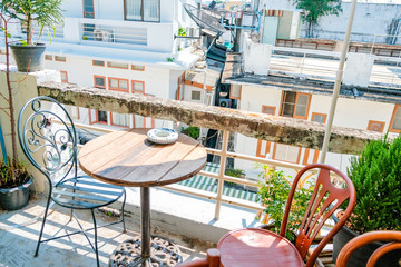 Beautiful terrace or balcony with small wooden table, chair and tree with evening city view, Garden cafe