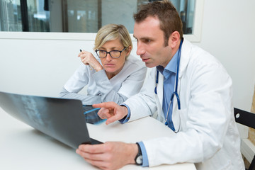 female and male doctor looking at a knee x-ray