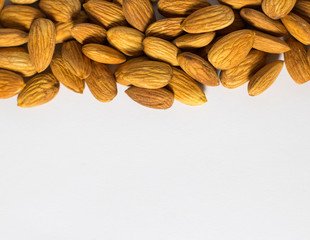 Frame with white background from handful of almonds, the nuts