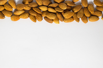 Frame with white background from handful of almonds, the nuts