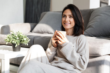 Beautiful young woman relaxing at a couch at home