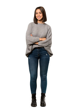 A full-length shot of a Young woman keeping the arms crossed in frontal position over isolated white background