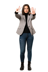 Obraz premium A full-length shot of a Young business woman counting eight with fingers over isolated white background