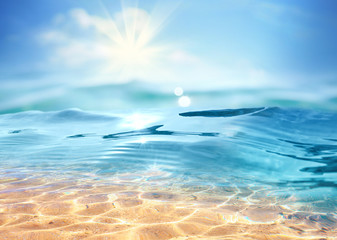 Summer landscape, nature of tropical with rays of sun light. Beautiful sun glare in wave of transparent blue water on beach against blue sky. Copy space, summer vacation concept.