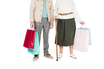 cropped view of retired couple standing with shopping bags isolated on white