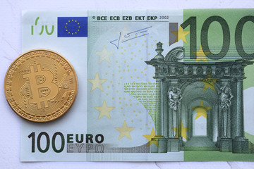 Bitcoin, virtual money . golden symbolic coins of bitcoins in Euro 100 banknote. Exchange bitcoin. Concept worldwide cryptocurrency.