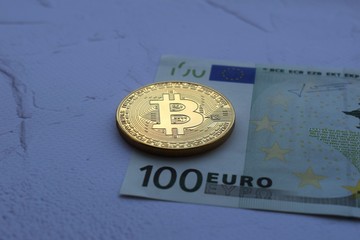 Bitcoin, virtual money . golden symbolic coins of bitcoins in Euro 100 banknote. Exchange bitcoin. Concept worldwide cryptocurrency.