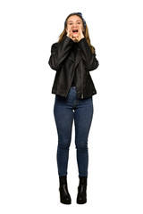 A full-length shot of a Teenager girl with leather jacket shouting and announcing something on isolated white background