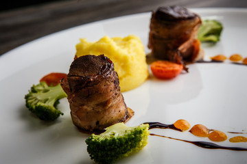 macro two meat pieces roasted in bacon with puree and broccoli