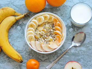 Healthy breakfast. Close-up, top view, isolated background. Concept of healthy and tasty food. Fitness breakfast. muesli bowl with sliced banana. Muesli breakfast with oatmeal cereals raisins. 