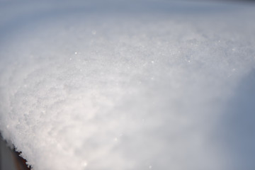snow structure, close up of snow in the sun with light color and front blur