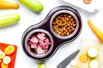 Dogfood set with cut vegetables and knife on table background top view