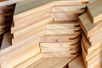 The stack of wooden blanks for furniture manufacturing in the carpenter workshop. Soft focus