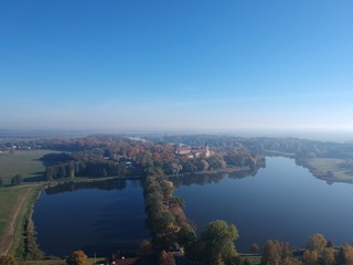 Drone photo of Nesvizh Castle in autumn on a hazy day. Minsk Region, Belarus. Site of residential castle of the Radziwill family. 