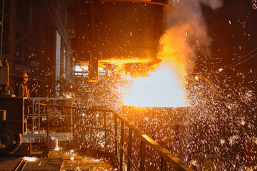 Steelmaker at ingot casting. Electric arc furnace shop EAF. Metallurgical production.