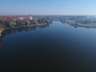 Fototapeta na wymiar Drone photo of Nesvizh Castle in autumn on a hazy day. Minsk Region, Belarus. Site of residential castle of the Radziwill family. 