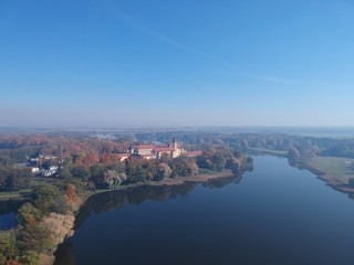Drone photo of Nesvizh Castle in autumn on a hazy day. Minsk Region, Belarus. Site of residential castle of the Radziwill family. 
