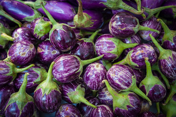 Fototapeta na wymiar Close up on small round purple eggplants for sale at a farmers market