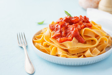 Pasta, tagliatelle with tomato sauce and bell pepper.