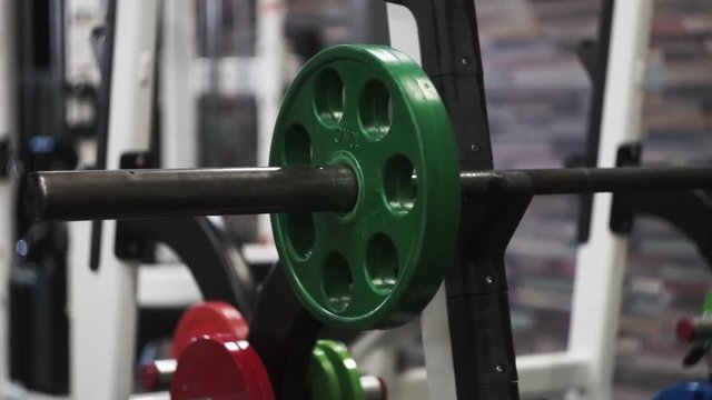 Man adding weigh plates to olympic bar between sets of push press chest sets.