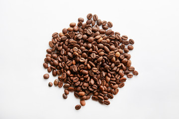 Roasted brown coffee beans scattered on white table with a lot copy space for text. Flat lay composition. Close up, top view, background.