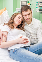 Happy family at hospital. Pregnant woman with her husband in medical clinic
