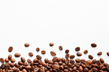 Roasted brown coffee beans scattered on white table with a lot copy space for text. Flat lay...