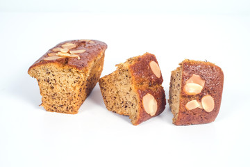 Homemade banana cake with almond and nuts on white background.