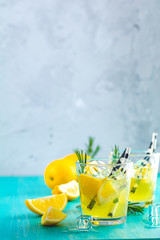 Lemon alcohol drink cocktail with ice, lemon and rosemary