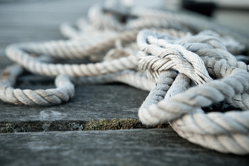 Close up of a sailing rope on a wooden pier with depth of fields 