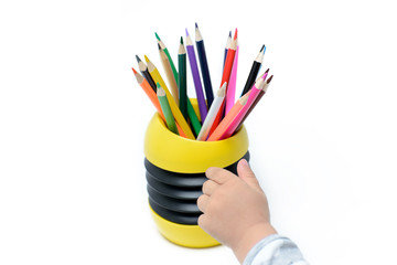 Naklejka premium Color pencils and baby hand on white background