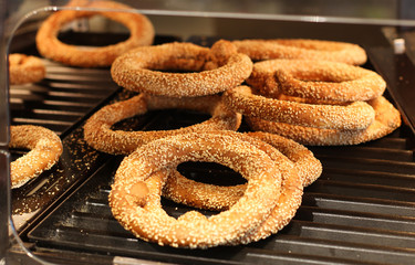 fresh crusty bread rolls or traditional bagels with sesame seeds on the showcase of the bakery in the supermarket