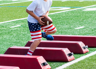 Football player running over barriers catching ball