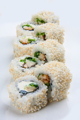 Sushi roll in sesame with eel and cheese on white background